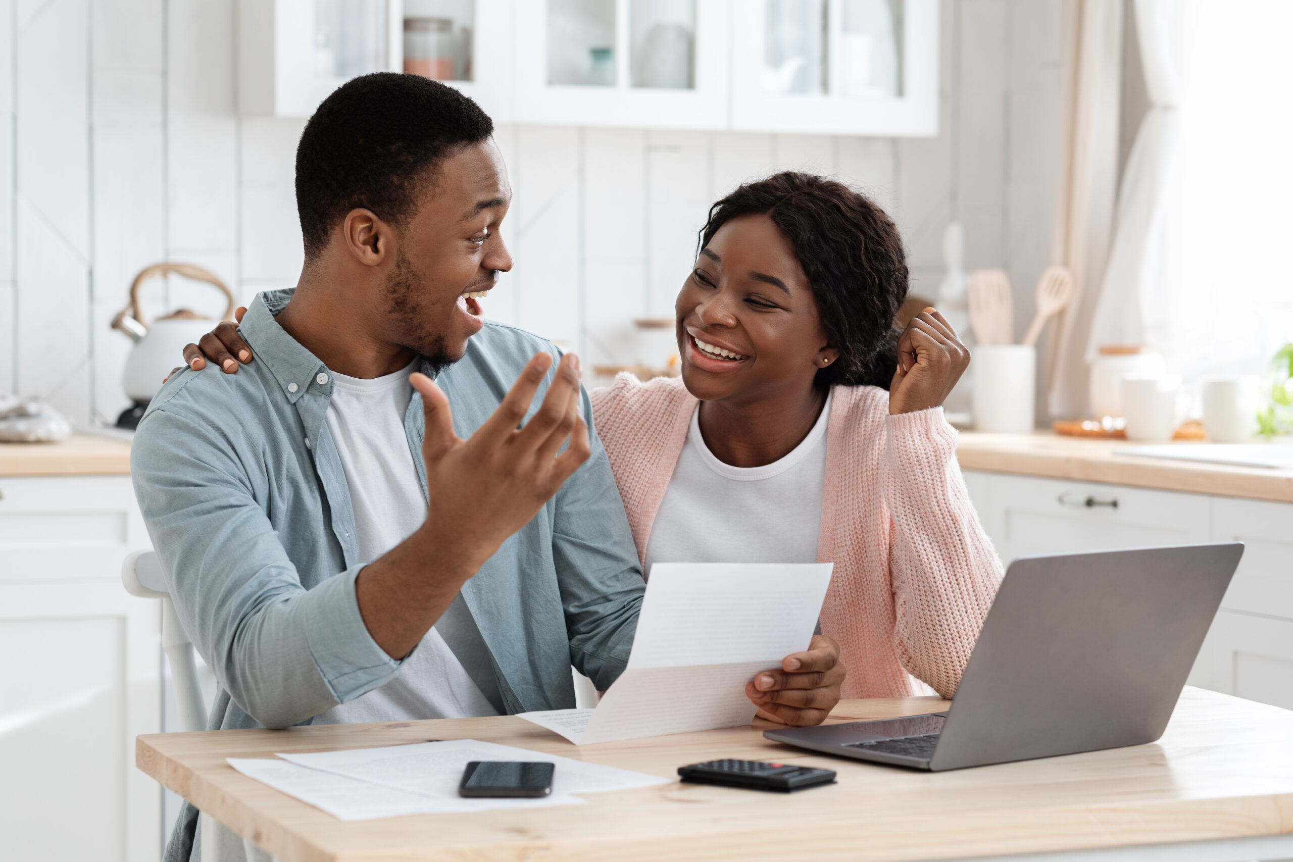 Portrait Of Happy Excited Black Married Couple Reading Insurance Documents In Kitchen