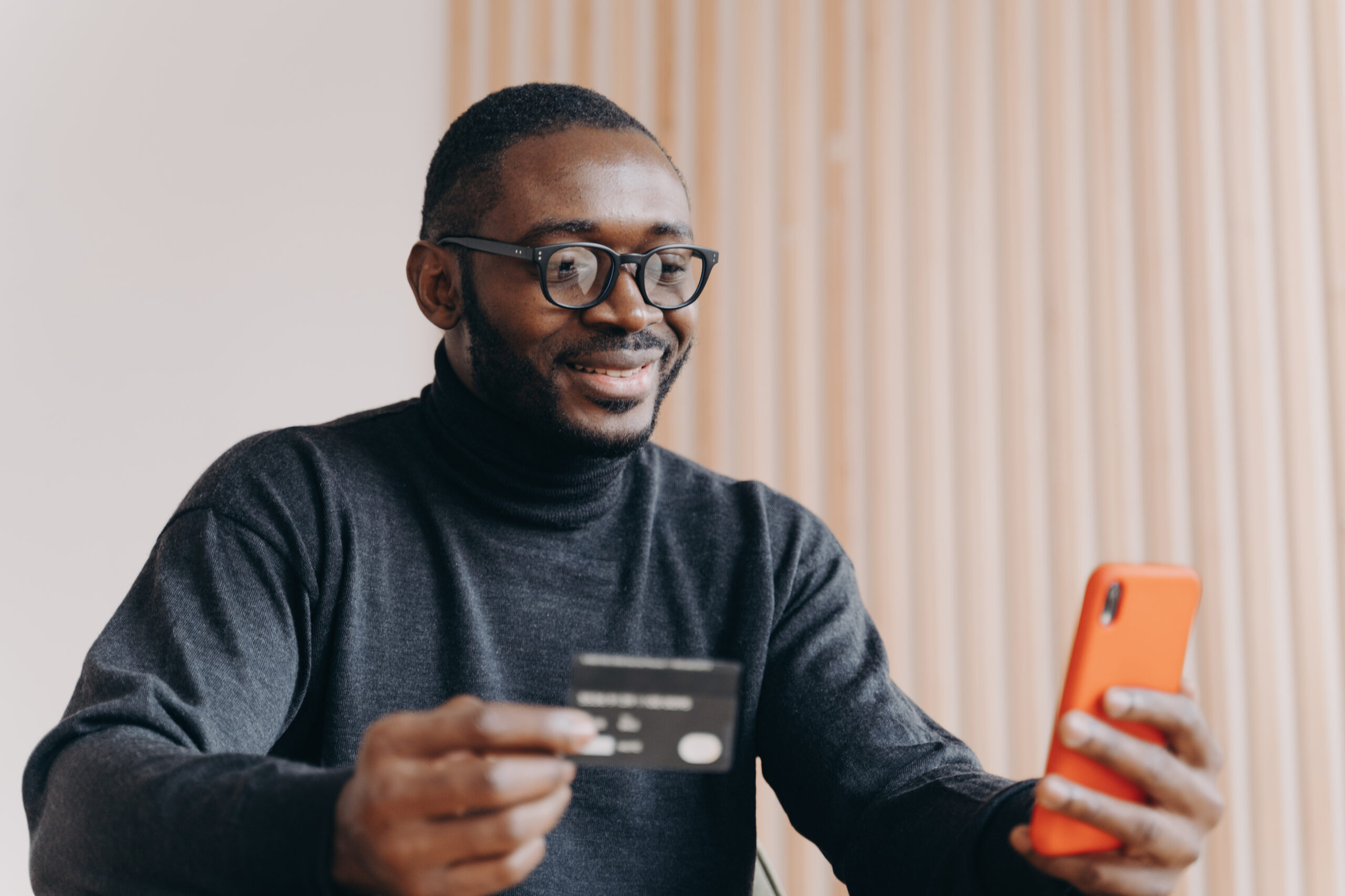 Young Happy African American Male Entrepreneur With Credit Card Using E Banking App On Smartphone