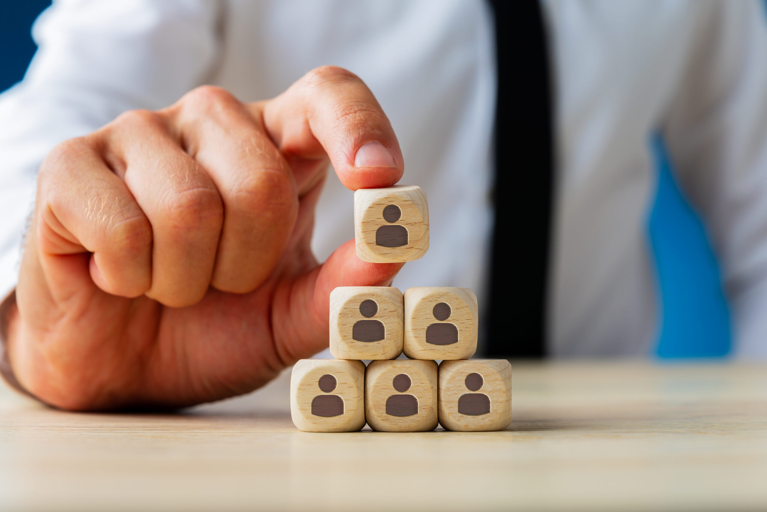 Business Executive Stacking Wooden Dices With People Icons On T