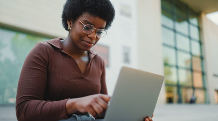 Female Entrepreneur Working On Laptop Outdoors. African American